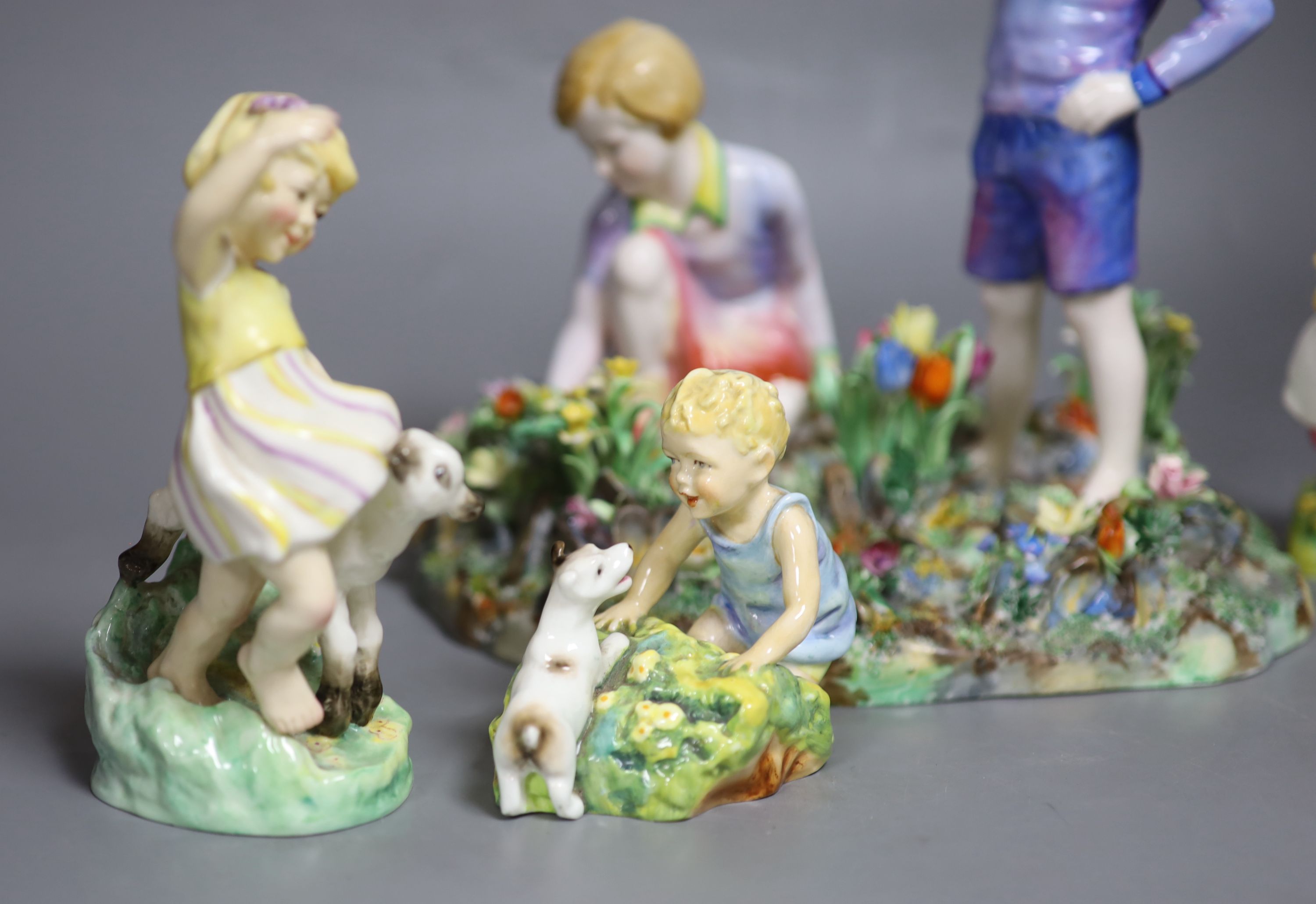 Four Royal Worcester figures of children by E.G. Doughty: 3150, 3076, 3103, 1416, and a larger Staffordshire table centre of a boy and